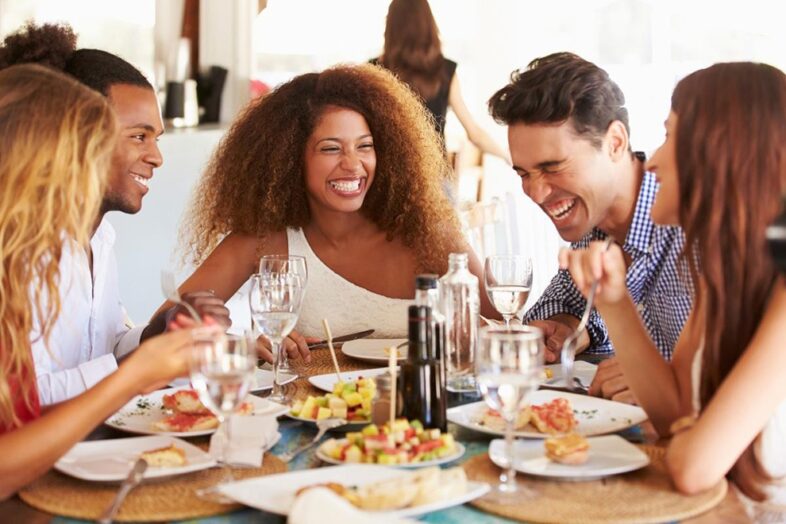 A group of people sitting at a table with plates and glasses.