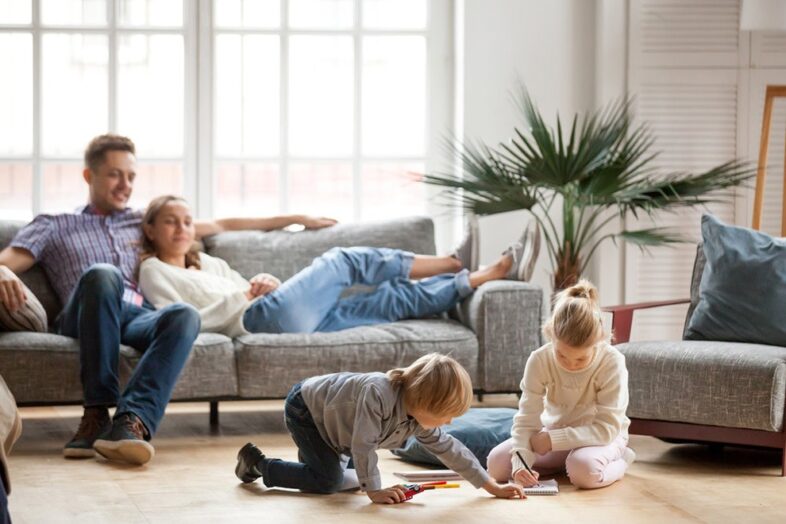 A family sitting on the floor in front of a couch