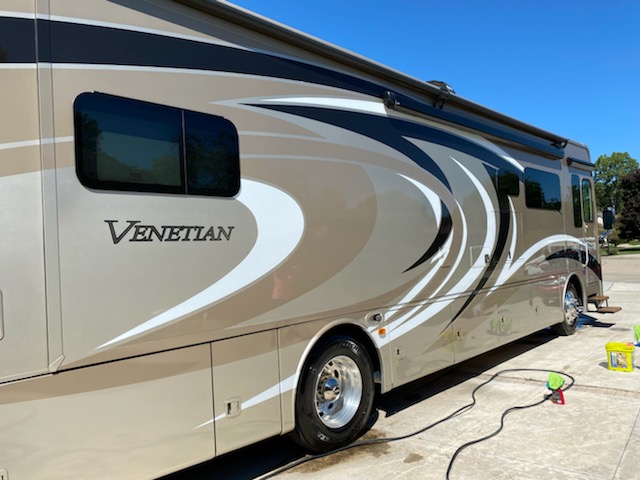 A large rv parked in the driveway of a house.