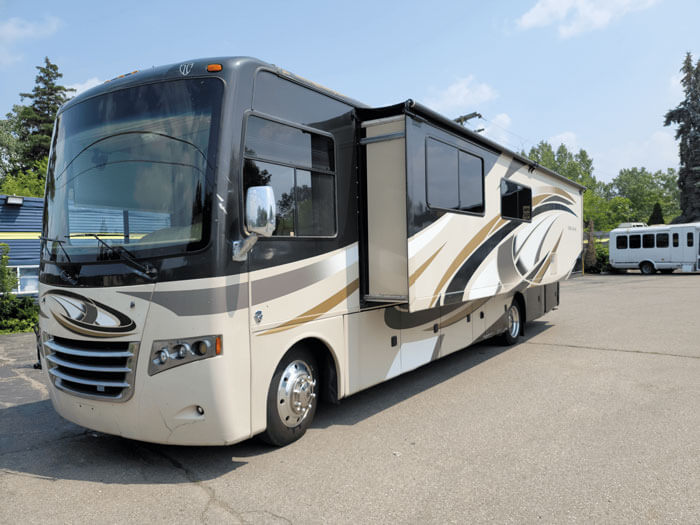 A large white and black rv parked in the parking lot.