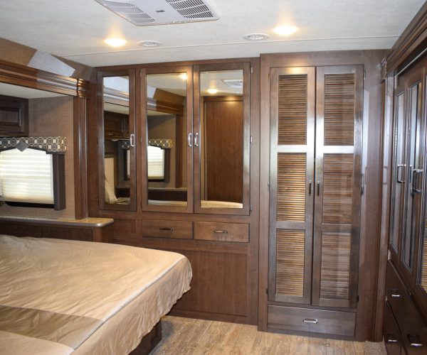 A bedroom with a bed, dresser and mirror.