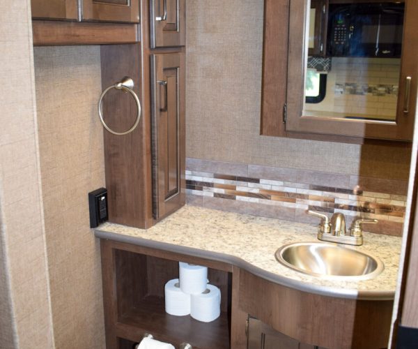 A bathroom with a sink, toilet and mirror.