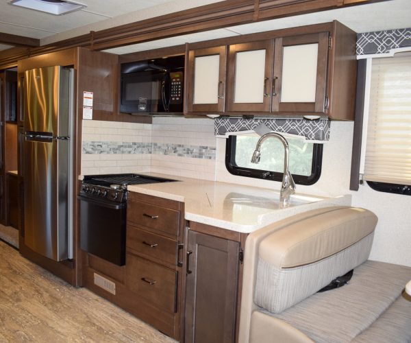 A kitchen with brown cabinets and white counters.