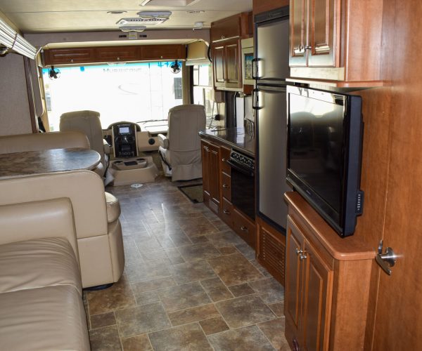 A living room with a couch, television and microwave.