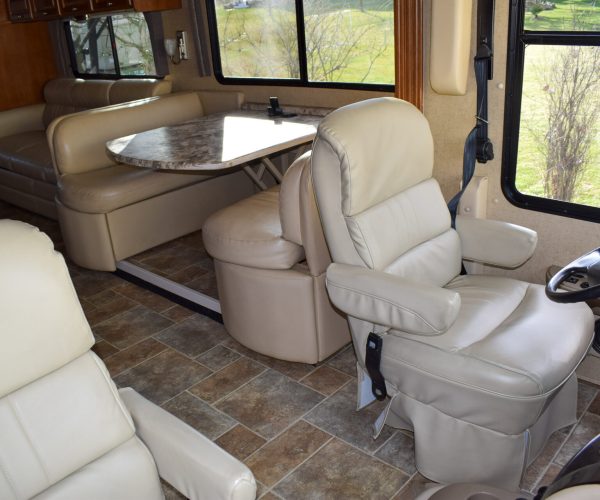 A large motorhome with many seats and tables.