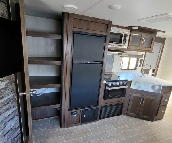 A kitchen with a refrigerator and microwave in it.