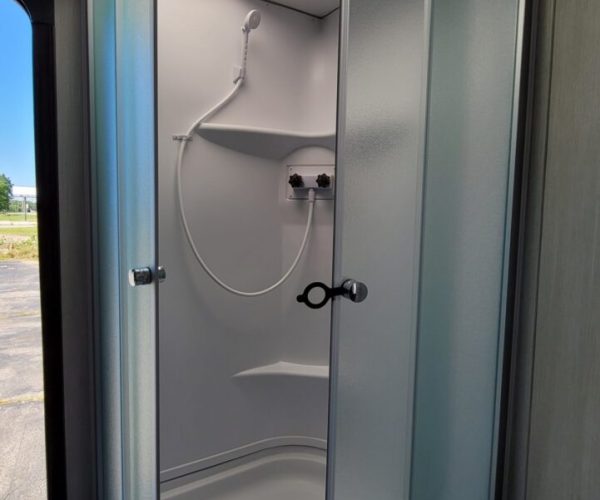 A shower stall with a door open and the outside of it.