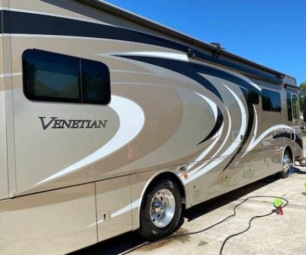 A large rv parked in the driveway of a house.