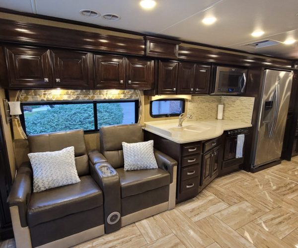 A living area with leather couches and a sink.