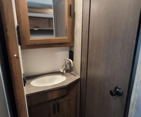 A bathroom with a sink and mirror in it