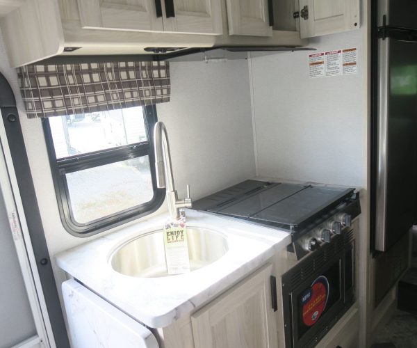 A kitchen with white cabinets and black appliances.