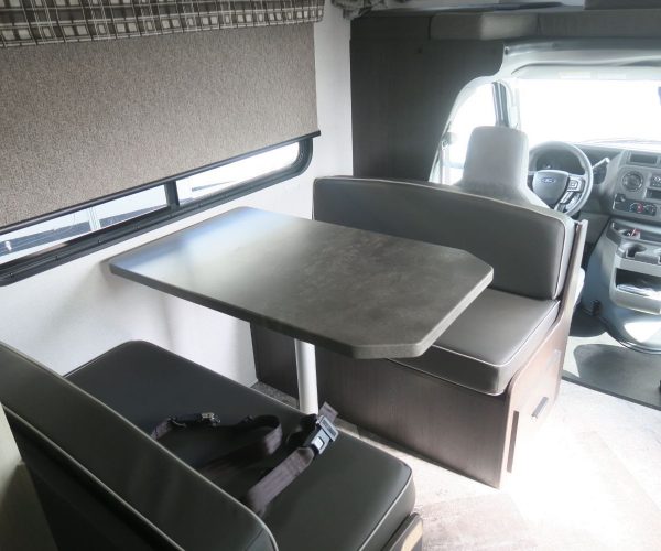 A table and chairs in the back of an rv.