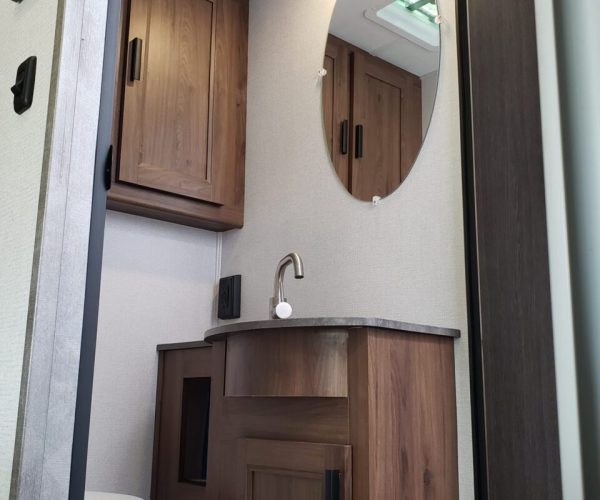 A bathroom with wood cabinets and a toilet.