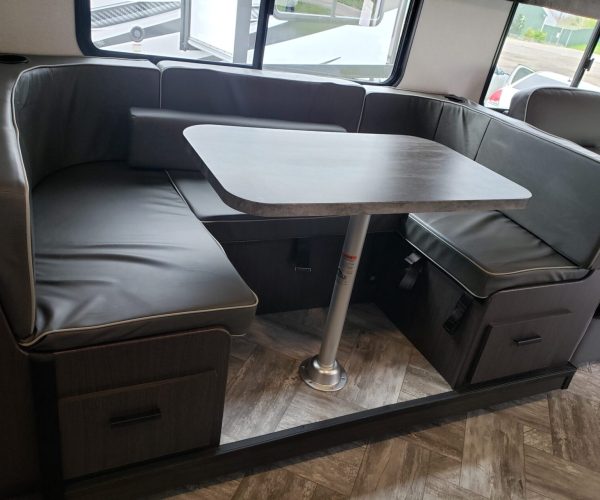 A table and chairs in the corner of a bus.