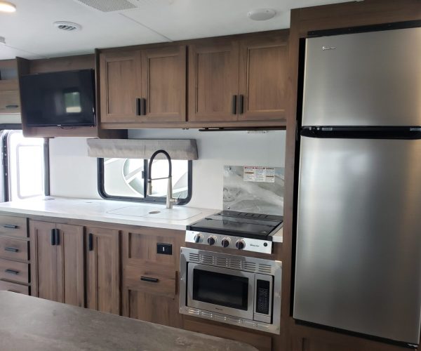 A kitchen with brown cabinets and stainless steel appliances.