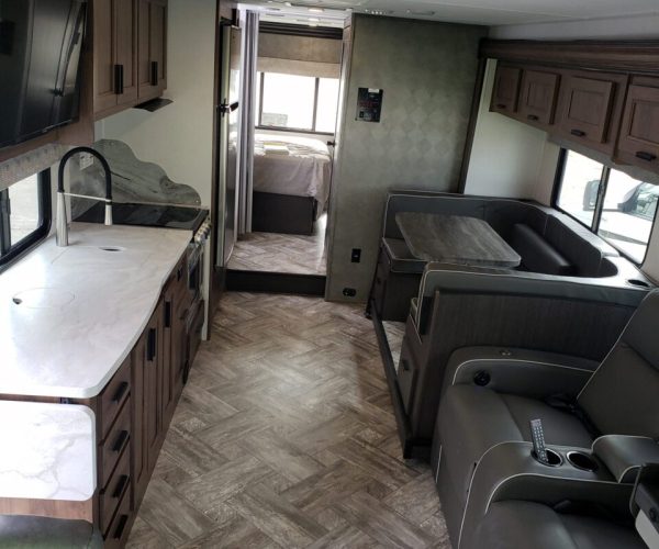 A kitchen with a sink, stove and refrigerator.